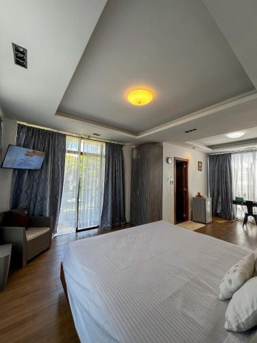 a bedroom with a large bed and a living room at The Hermitage Tagaytay-Presidential Suite in Malabag