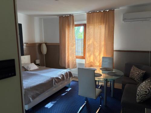 a bedroom with a bed and a table and a couch at Újszeged apartman in Szeged