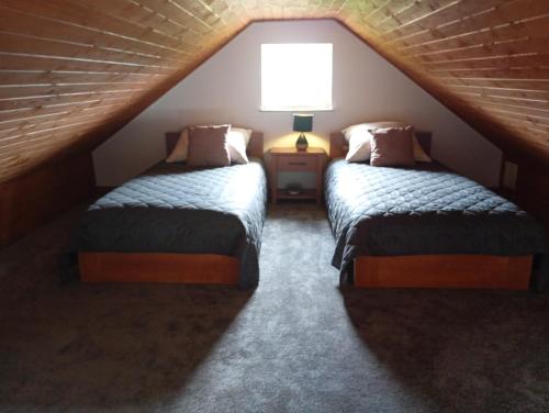 a attic room with two beds and a lamp at Gawędówka in Czchów