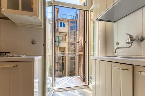 a kitchen with a glass door to a window at Piazza di Spagna Historic Flat in Rome