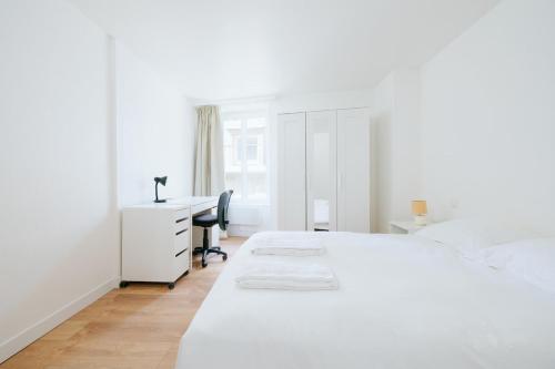 a white bedroom with a desk and a bed at Le Triplex du Vœu Spacious Apartment in Cherbourg en Cotentin