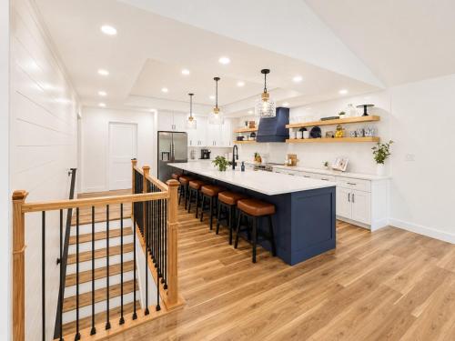 a kitchen with a blue island with bar stools at The Ozark Acre 6BDR Lakefront in Sunrise Beach
