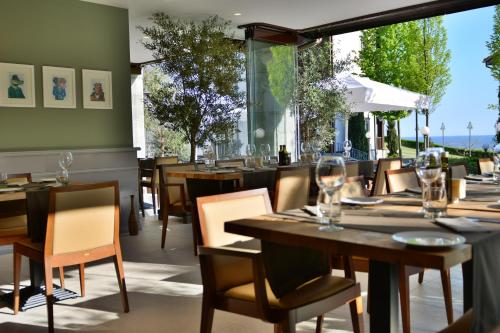 een restaurant met tafels en stoelen en een groot raam bij Thracian Cliffs Golf & Beach Resort in Kavarna