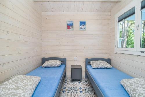 two beds in a room with two windows at Greckie Domki ZEUS in Stegna