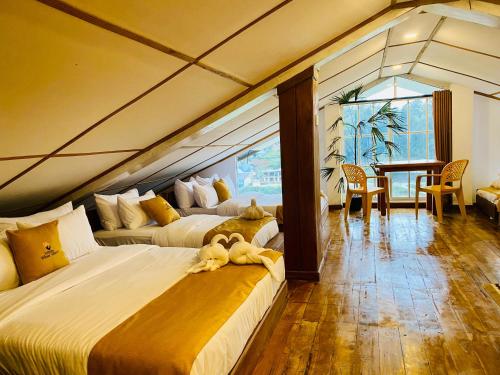 a bedroom with two beds and a dining room with a table at Infinity Winter Resort in Nuwara Eliya