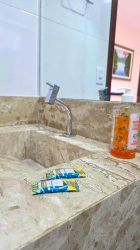 a pile of toothpaste sitting on a counter next to a sink at Pássaros do Cerrado Suítes in Alto Paraíso de Goiás