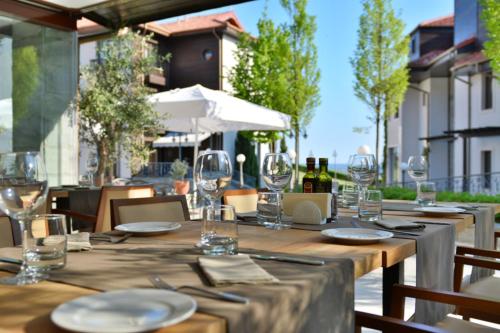 een houten tafel met wijnglazen op een patio bij Thracian Cliffs Golf & Beach Resort in Kavarna