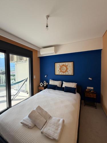 a bedroom with a large bed with a blue wall at Karen's Favorite in Skala Potamias