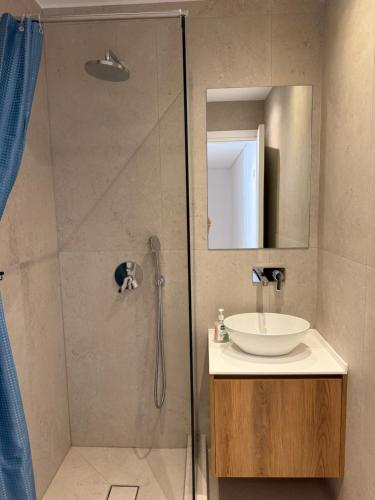 a bathroom with a shower with a sink and a mirror at Karen's Favorite in Skala Potamias