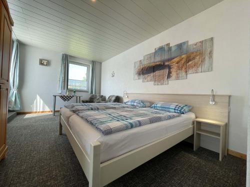 a bedroom with a bed with two paintings on the wall at Pension Murra in Stedesdorf