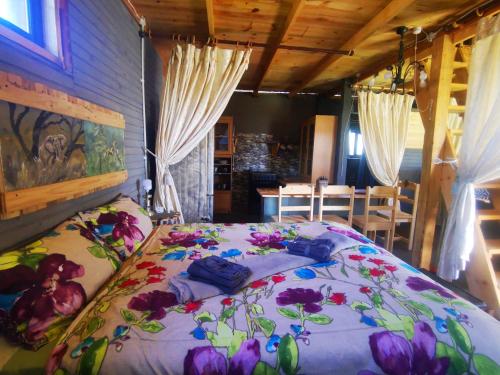 a bedroom with a large bed with flowers on it at Wagon Wheel Gabin in Chrissiesmeer
