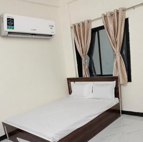 a bedroom with a bed with a tv on the wall at New Vivaantaa Hotel in Aurangabad