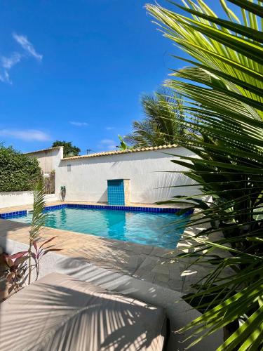 a swimming pool in front of a white building at Renascer Suites in Búzios