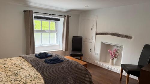 a bedroom with a bed and a window and a chair at The Burrow in Kendal