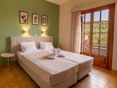 a bedroom with a bed with white sheets and a window at Tony studio & apartments in Laganas