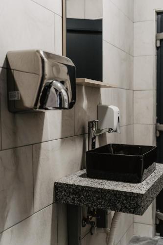 a bathroom with a black sink and a paper towel dispenser at Camping Colibita in Colibiţa