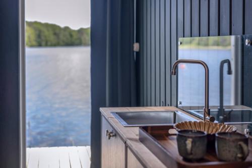 a kitchen with a sink and a view of the water at The Floating Lodge in Linköping