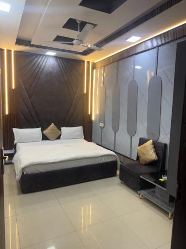a bedroom with a large bed and a chair at Hotel American in Sahāranpur