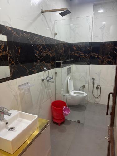 a bathroom with a sink and a toilet and a shower at Hotel American in Sahāranpur