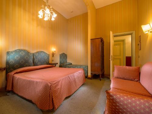 1 dormitorio con 2 camas, silla y lámpara de araña en Centauro Hotel, en Venecia