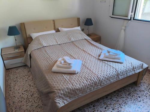 a bedroom with a bed with two towels on it at Nicks house by zarkco in Artemida