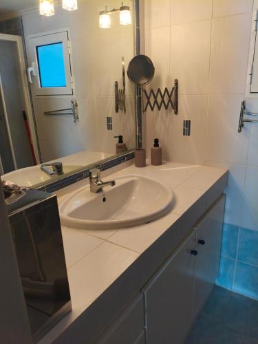 a bathroom with a sink and a mirror at Nicks house by zarkco in Artemida