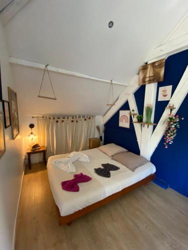 a bedroom with a bed with a blue wall at Le Pivoine in Gury