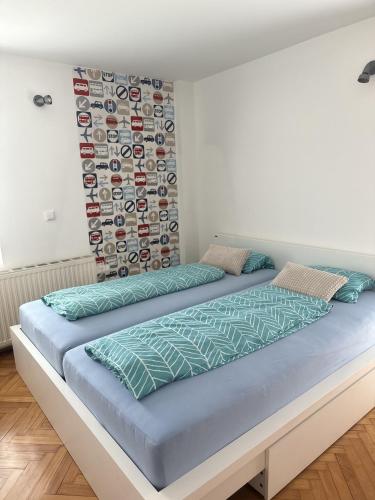 two beds in a bedroom with a wall at Apartment Sawetz - Ptuj in Ptuj