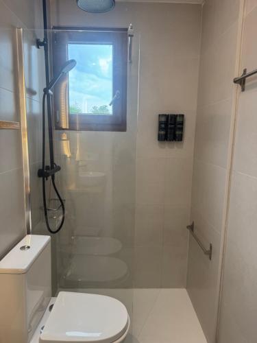 a bathroom with a shower and a toilet and a window at VillaBrisaeta, villa costera a un paso de todo. in Benicàssim