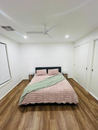 a bedroom with a large bed in a white room at Mickleham Prestige Homestay in Mickleham