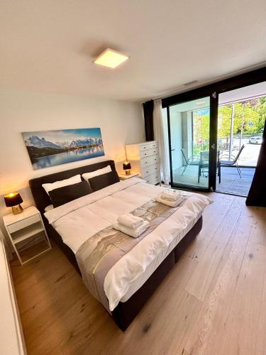 a bedroom with a large bed and a large window at Heyko Holiday Interlaken in Interlaken