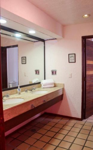 a bathroom with a large mirror and a sink at Ocean Bloom in Cancún