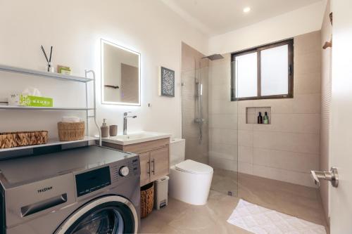 a bathroom with a washing machine and a toilet at Villa Ticalma in Parrita