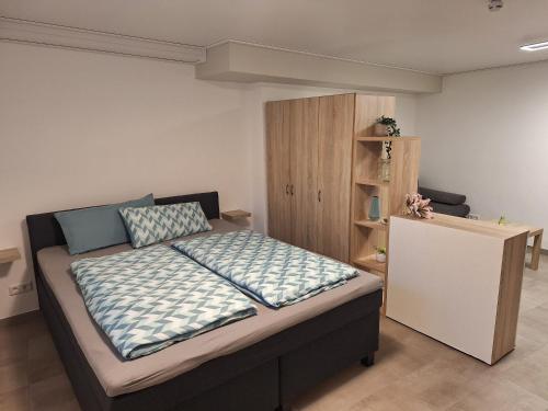 a bedroom with a bed and a book shelf at Das kleine SOTEL in NuÃŸbaum