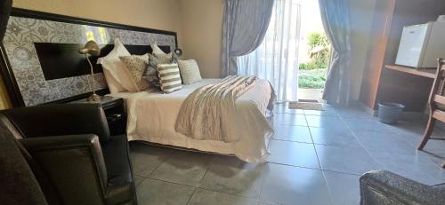 a bedroom with a bed and a chair and a window at GerSan Oasis in Nigel