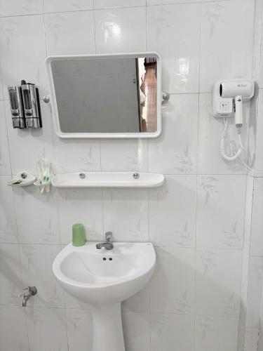 a white bathroom with a sink and a mirror at Hoa Phuong Hotel Phong Nha in Phong Nha