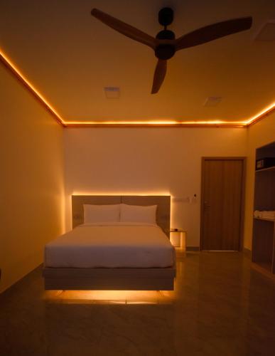 a bedroom with a bed with a ceiling fan at Maako Retreats in Milandu