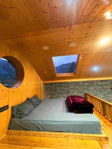 a bed in a small room with two windows at The Pravaas Resort in Barot 