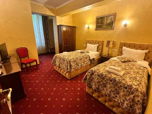 a hotel room with two beds and a red carpet at Vila Royal in Bacău