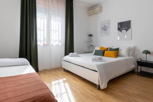 a bedroom with two beds and a window at Casa Orlando in Modena