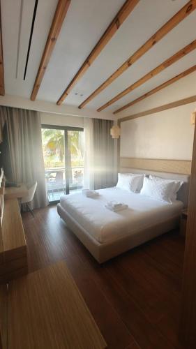 a large white bed in a room with a window at Hotel Lake Park Ksamil in Ksamil