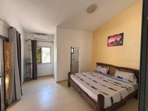 a bedroom with a bed in the corner of a room at Villa Symphonie Saly in Saly Portudal