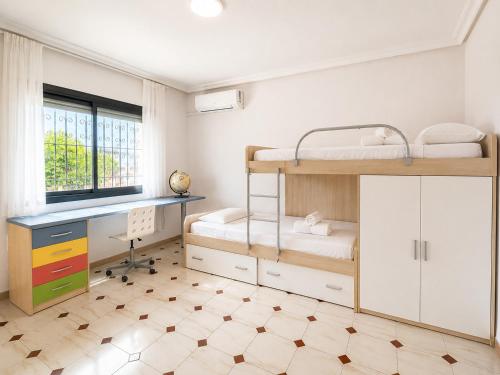 a bedroom with two bunk beds and a desk at Villa Portalmar in Benicarló