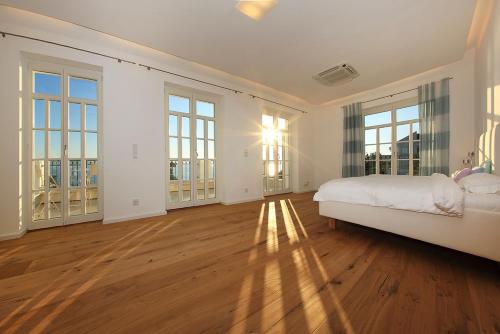 a large white bedroom with a bed and large windows at Luxury Beachfront Villa Smague with Sauna, Zadar in Diklo