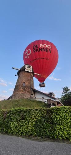 a red hot runner balloon in front of a building at Sky Ballonvaarten & Accommodaties in Tilburg