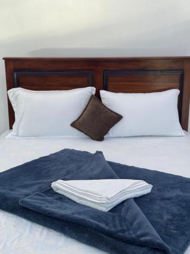 a blue towel sitting on top of a bed with pillows at Bhanuka Hevan Place in Ella
