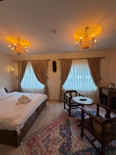 a bedroom with a bed and a table and chandeliers at Mardin Kent Suit Hotel in Mardin