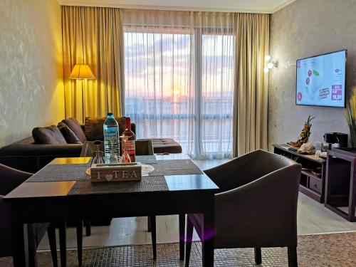 a living room with a table with chairs and a couch at Royal Beach Premium Residence- Sunny Beach in Sunny Beach