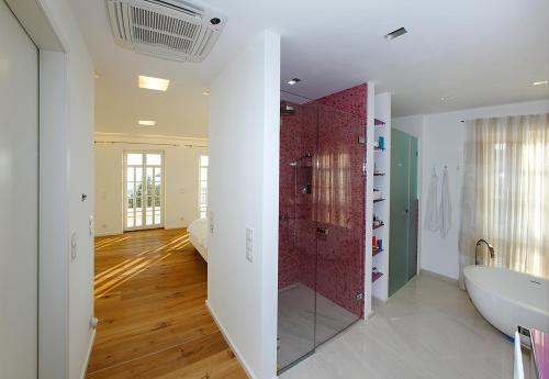a bathroom with a tub and a shower in a room at Luxury Beachfront Villa Smague with Sauna, Zadar in Diklo