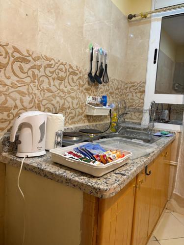 a kitchen counter with a sink and a tray of utensils at saidia 700 m de la plage in Saïdia